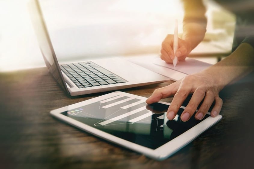 person using a tablet and laptop